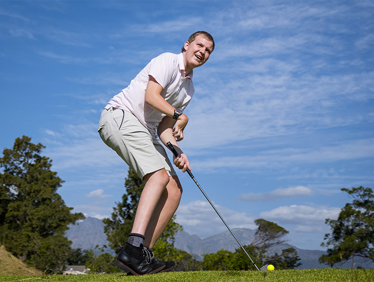Young male golfer prepares to tee off.